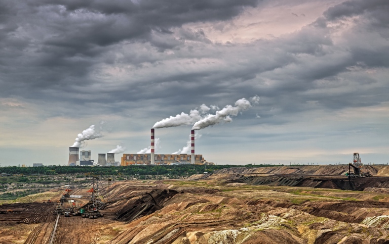 Kolkraftverk och kolgruva i östra Europa. Skorstenar släpper ut rök.